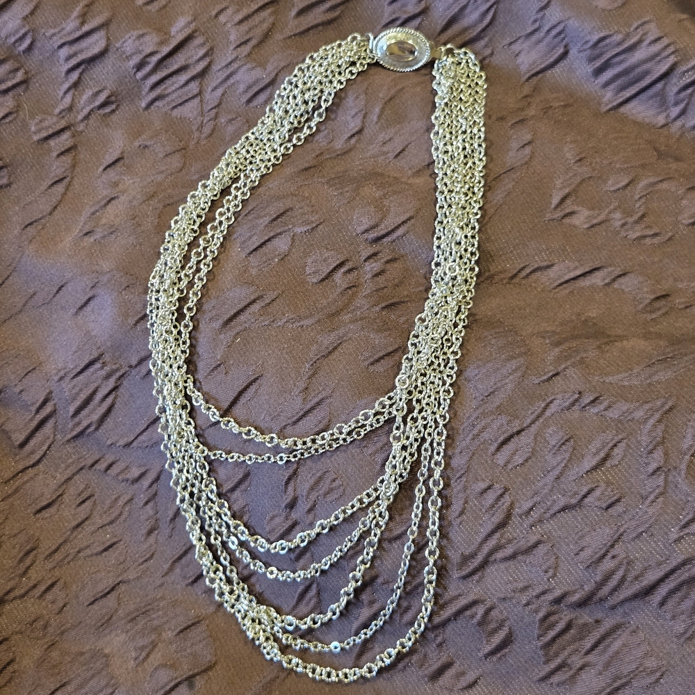 Avon silver-tone chain necklace featuring seven strands, oval box clasp. 1972